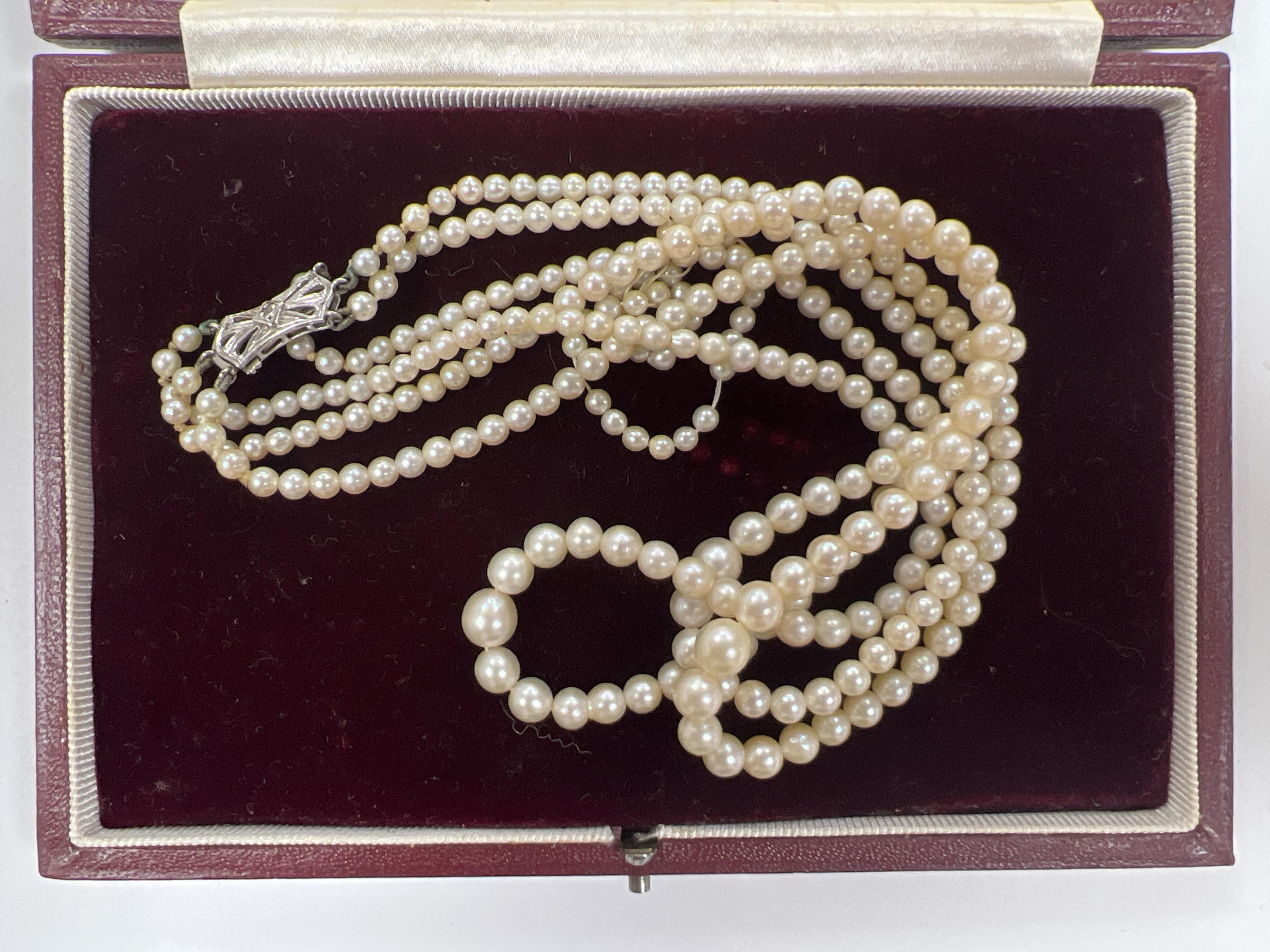 A triple strand graduated cultured pearl choker necklace, with diamond chip set 9ct white gold clasp, 38cm, in a Harrods box, together with some loose beads. Condition - fair